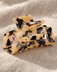 Close-up of the glossy honey and brown tortoise pattern and the interlocking teeth of the clip